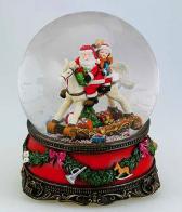 Boules à neige musicales de Noël disponibles sur commande (nous contacter) Boule à neige musicale de Noël avec globe en verre et Père Noël et enfant sur un cheval à bascule